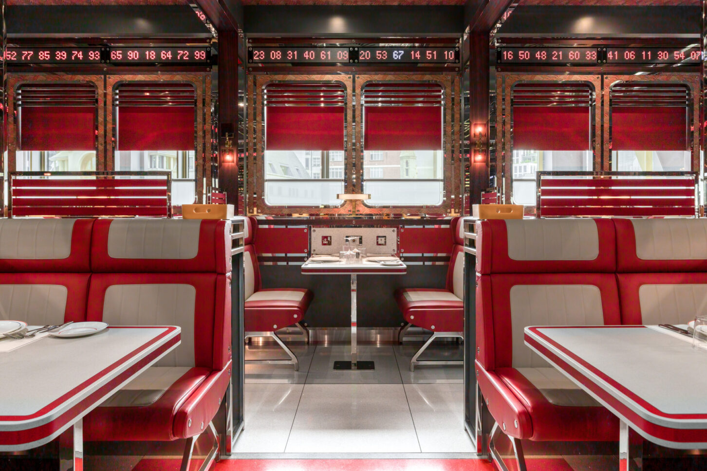 Booth seating facing city window with digital ticker displays — restaurant photographer London, Bob Bob Ricard City