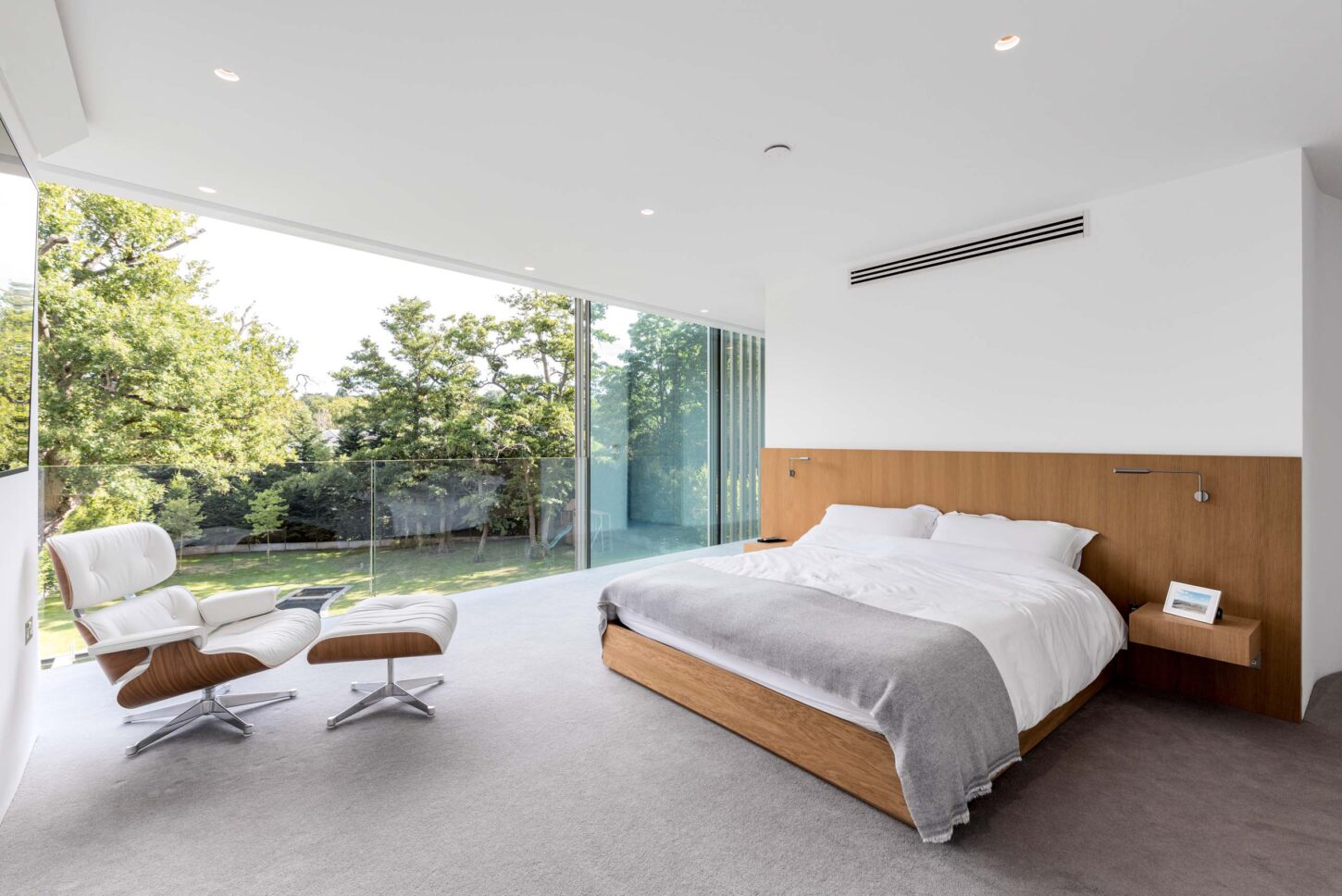 Bedroom with floor-to-ceiling windows overlooking garden — Greenways, designed by Eldridge Architects, London