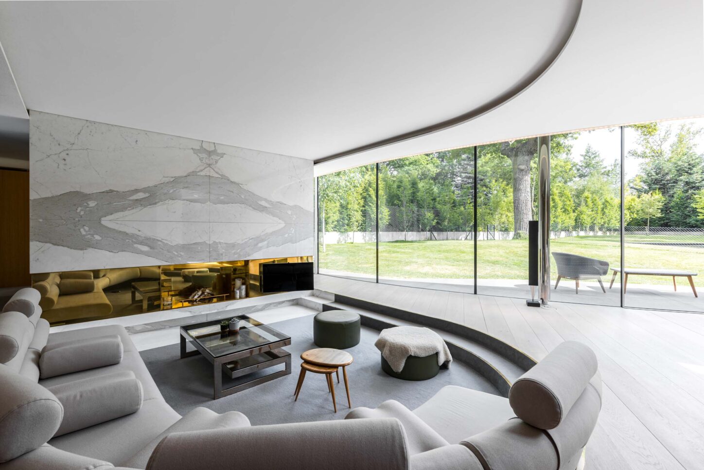 Curved white-walled living room with garden view — Greenways, designed by Eldridge Architects, London