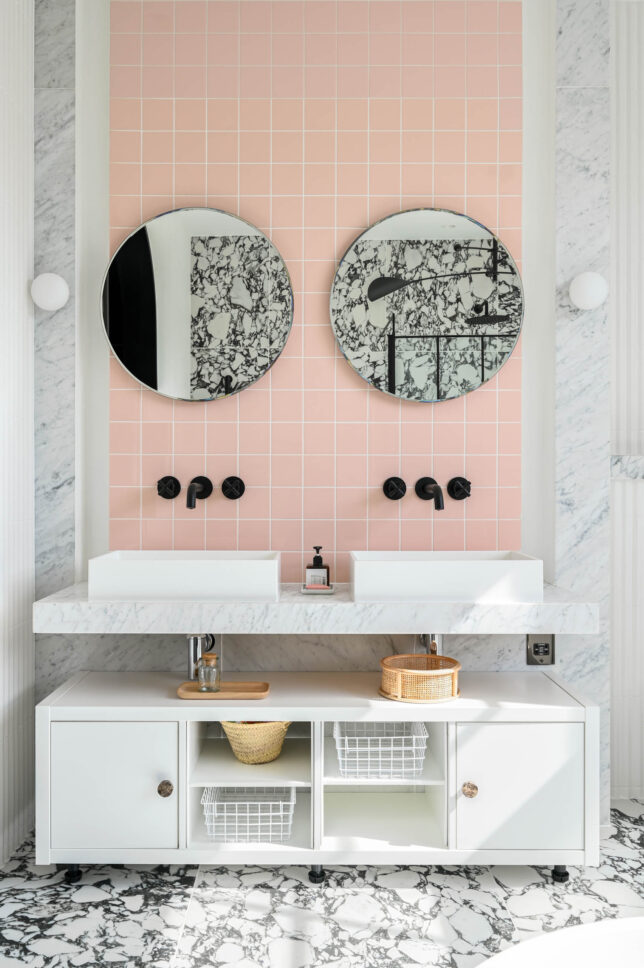 Bedroom interior with round mirror and pink wall art — designed by Sara Leonor Studio, London