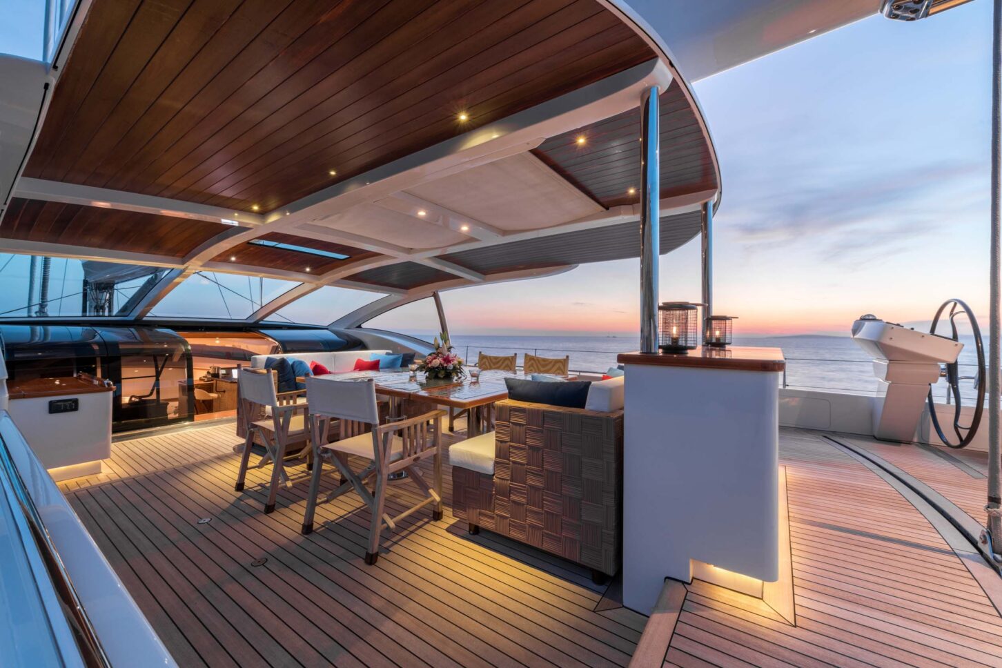 Yacht deck dining area at sunset with sea view