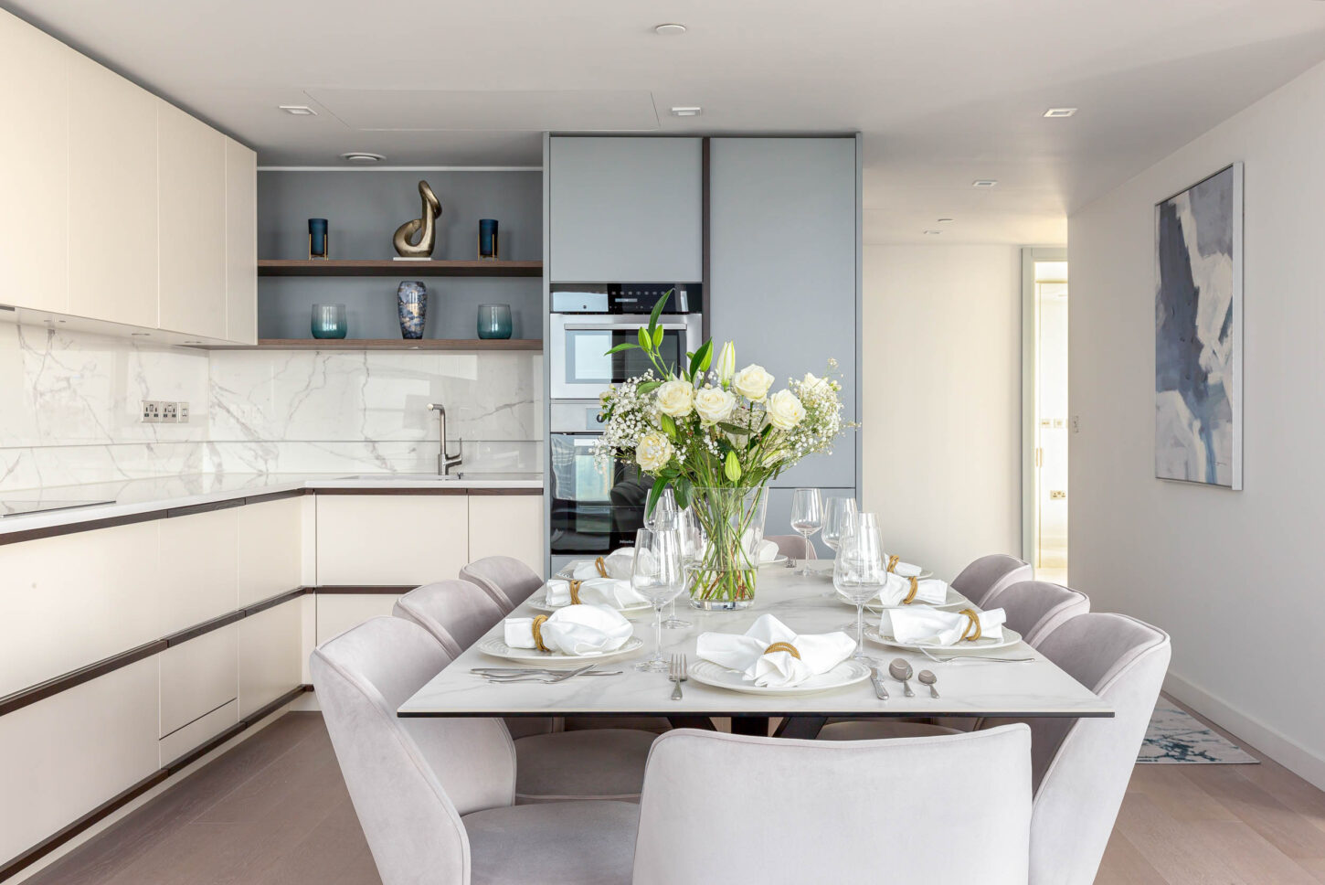 Marble kitchen and dining area with upholstered chairs and a formal table setting — interior photography for Housedesigner, London