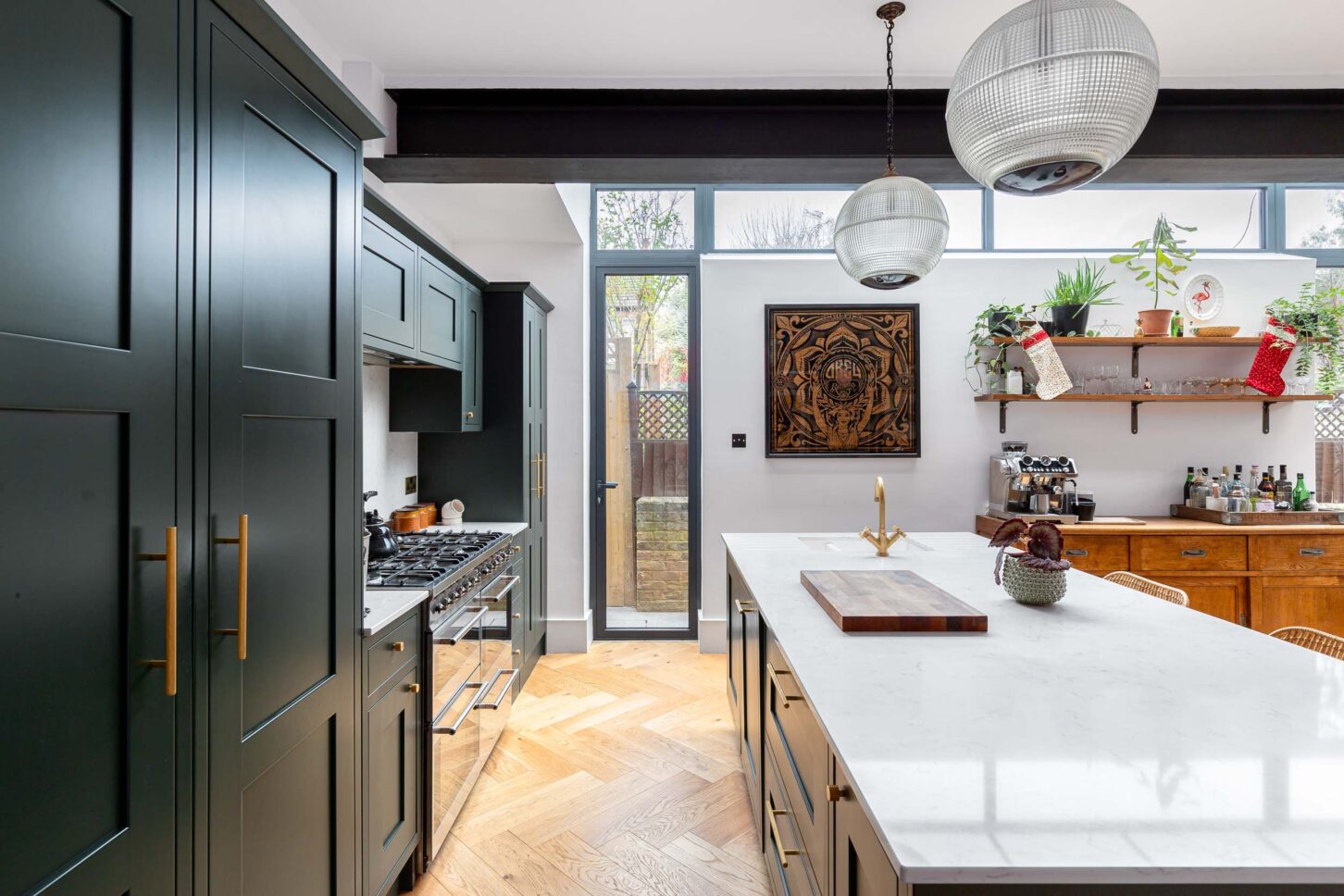 Dark green shaker kitchen with brass handles, marble island and herringbone wood floor — architectural photography for Architecture:WK, London