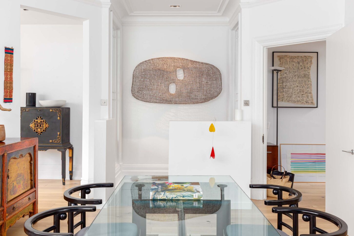 Dining room with glass table and curated art collection — interior photographer London, Hoban Design Wimbledon