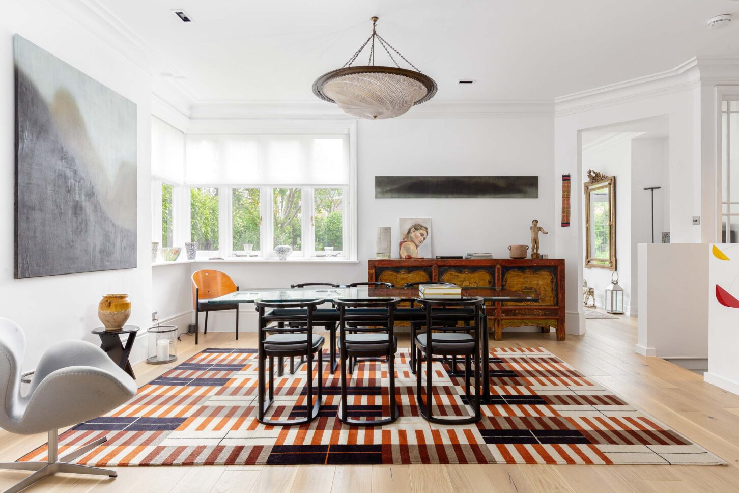 Bay-window dining room with patterned rug and antique sideboard — Hoban Design, Wimbledon Village