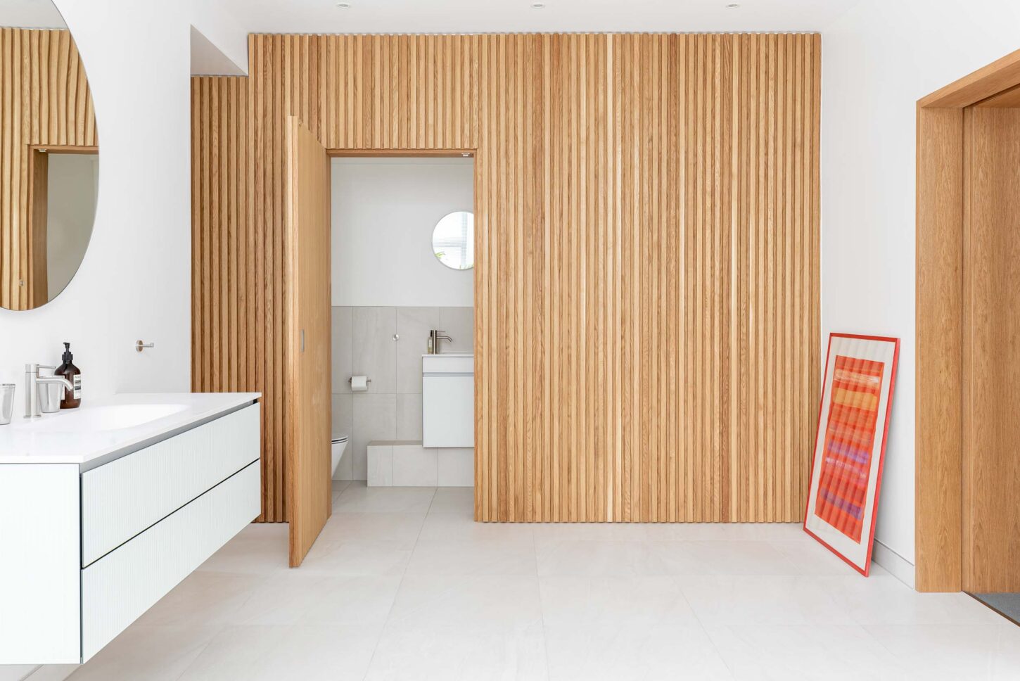 Fluted timber panelling concealing bathroom entrance — Hoban Design, Wimbledon
