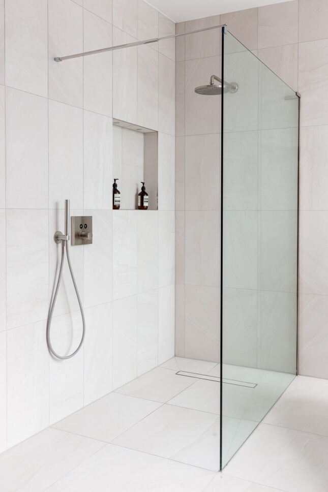 Walk-in shower with glass screen and stone tiling — interior photographer London, Hoban Design Wimbledon