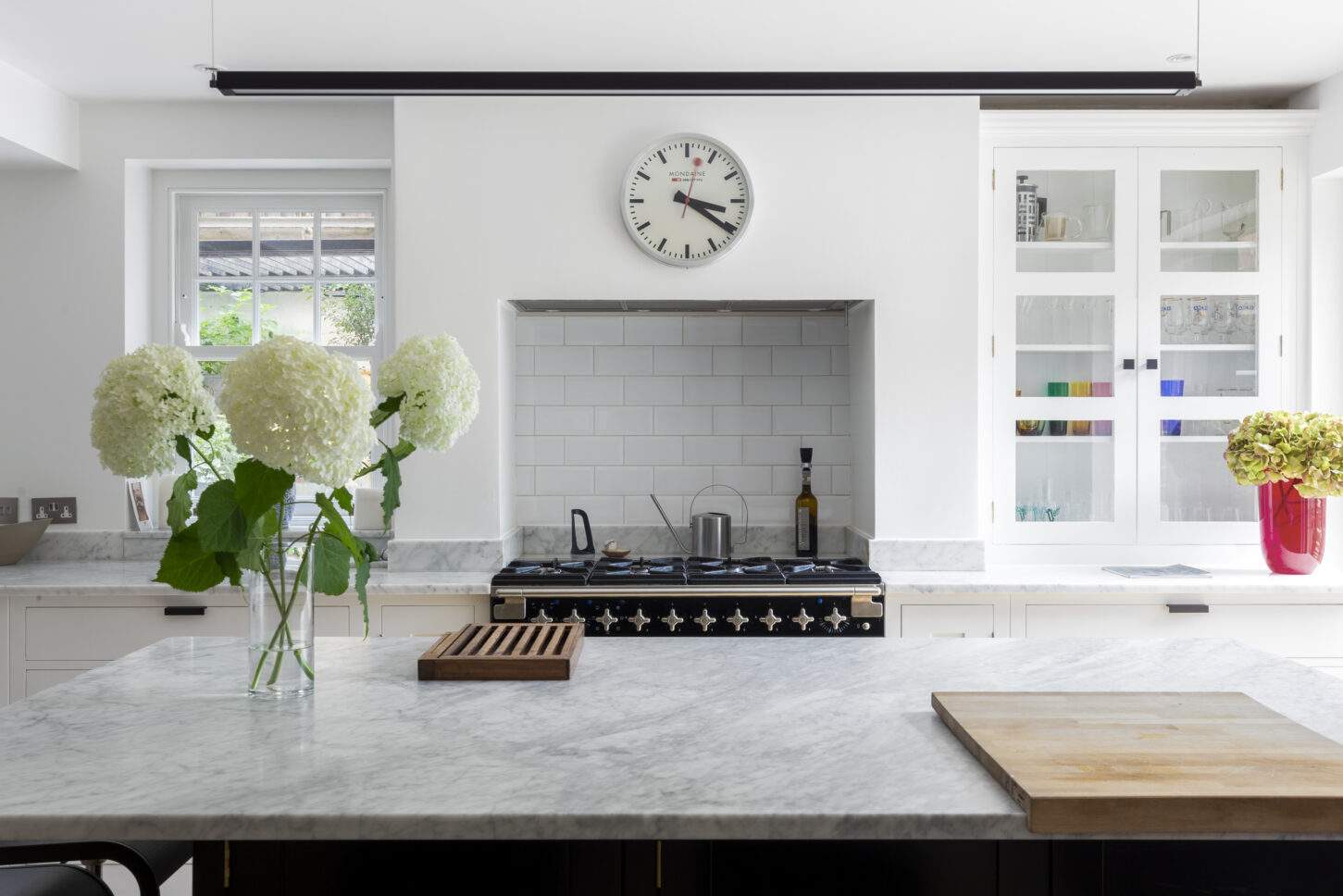 Marble kitchen island with range cooker and glazed cabinetry — interior photographer London, Hoban Design Wimbledon