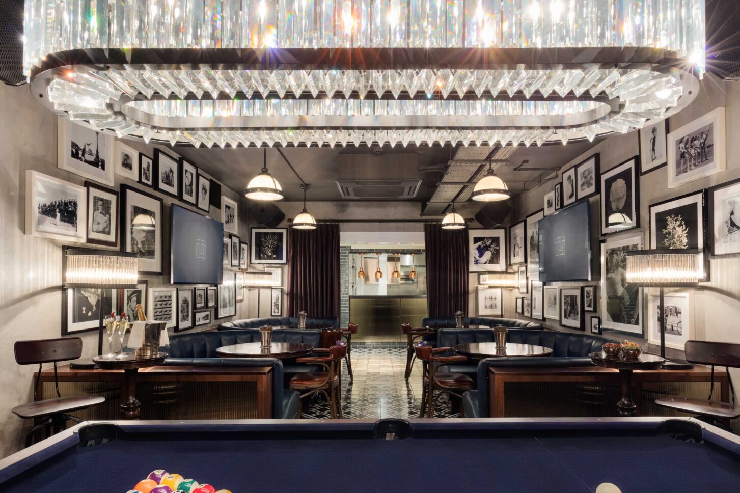 Pool table room with crystal chandelier and gallery wall — restaurant photographer London, private members' restaurant