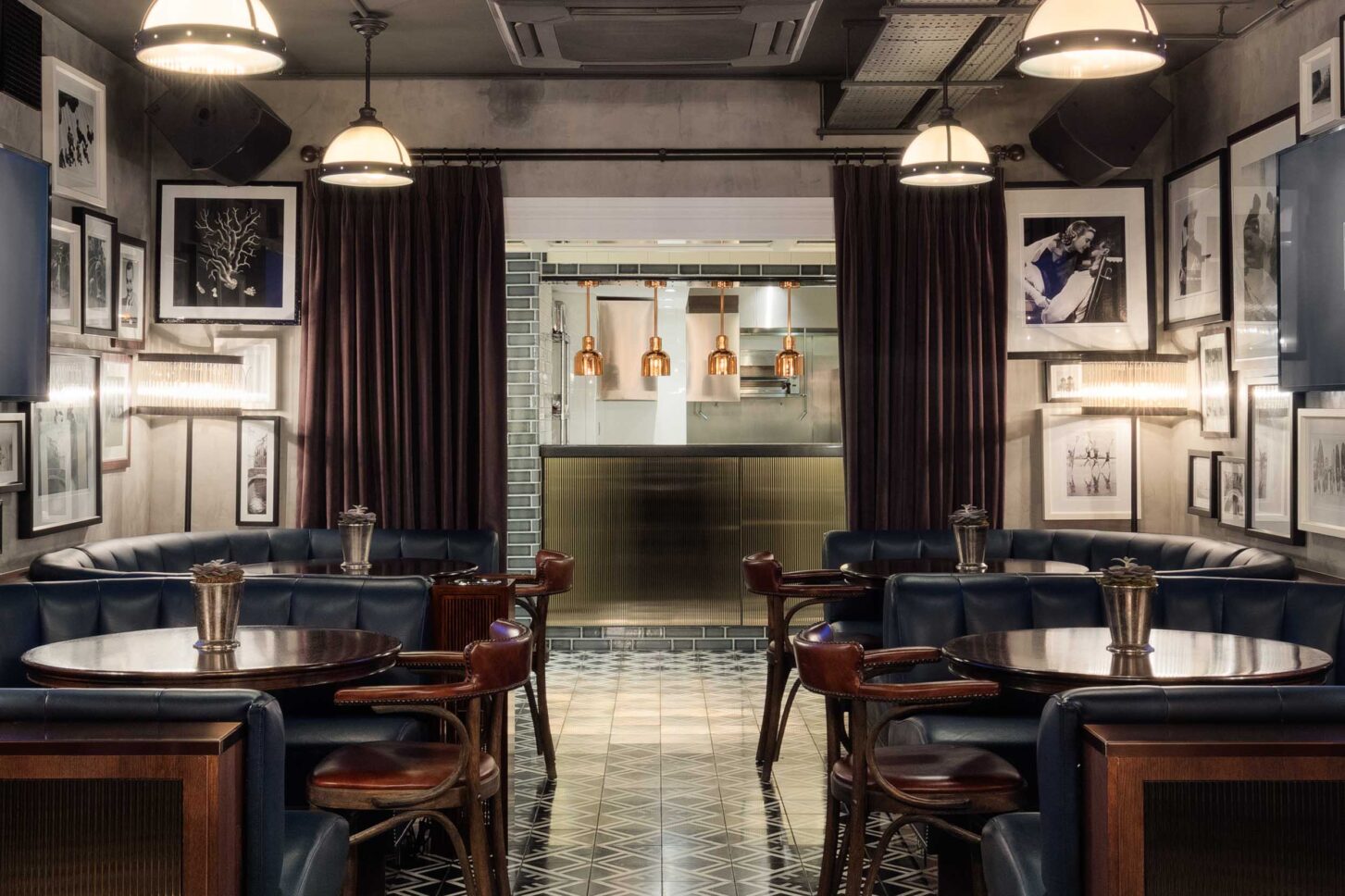 Booth seating and gallery wall leading to open kitchen — restaurant photographer London, private members' restaurant