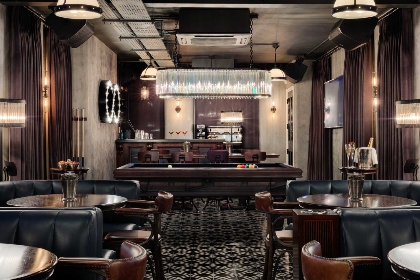 Pool table lounge with crystal chandelier and velvet booths — restaurant photographer London, private members' restaurant