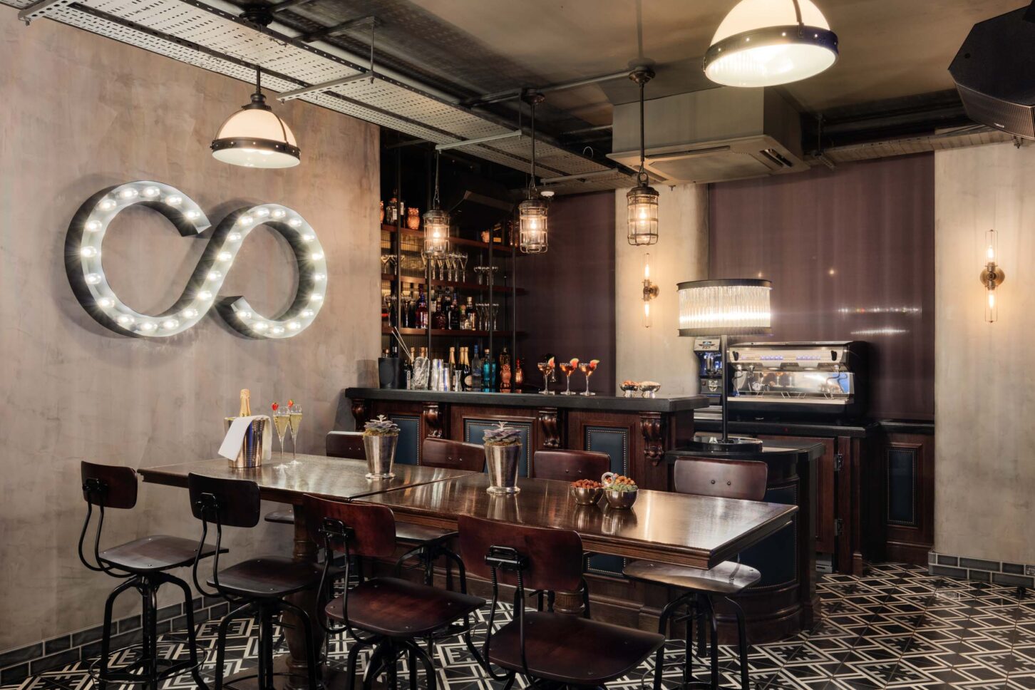 Wide bar view with infinity sign and industrial pendant lighting — private members' restaurant, restaurant photographer London
