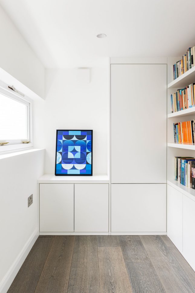 Hallway nook with built-in cabinetry, bookshelf, and framed artwork — Canonbury, designed by Unknown Makers, London