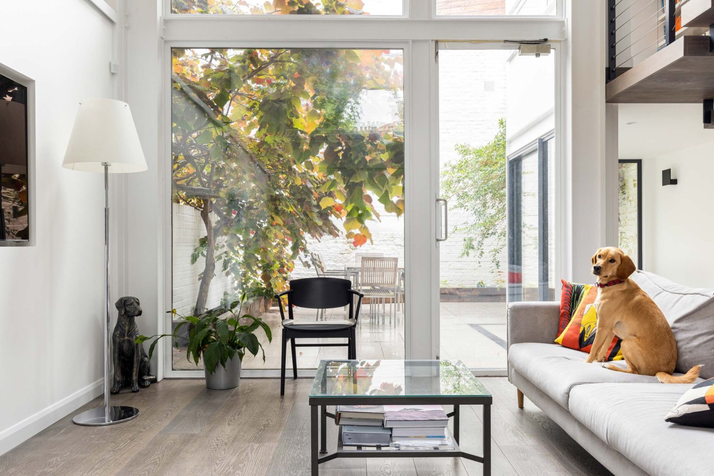 Living room with glass doors opening to a courtyard garden — Canonbury, designed by Unknown Makers, London