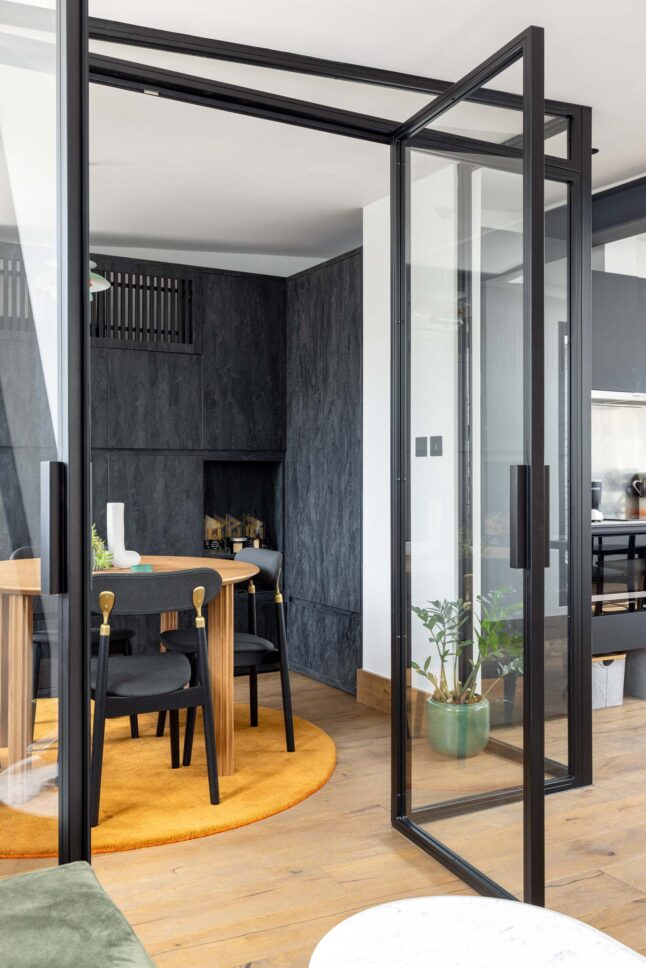 Office glass door opening to dark stone-clad meeting room, designed by Unknown Makers — Kingsland project, London
