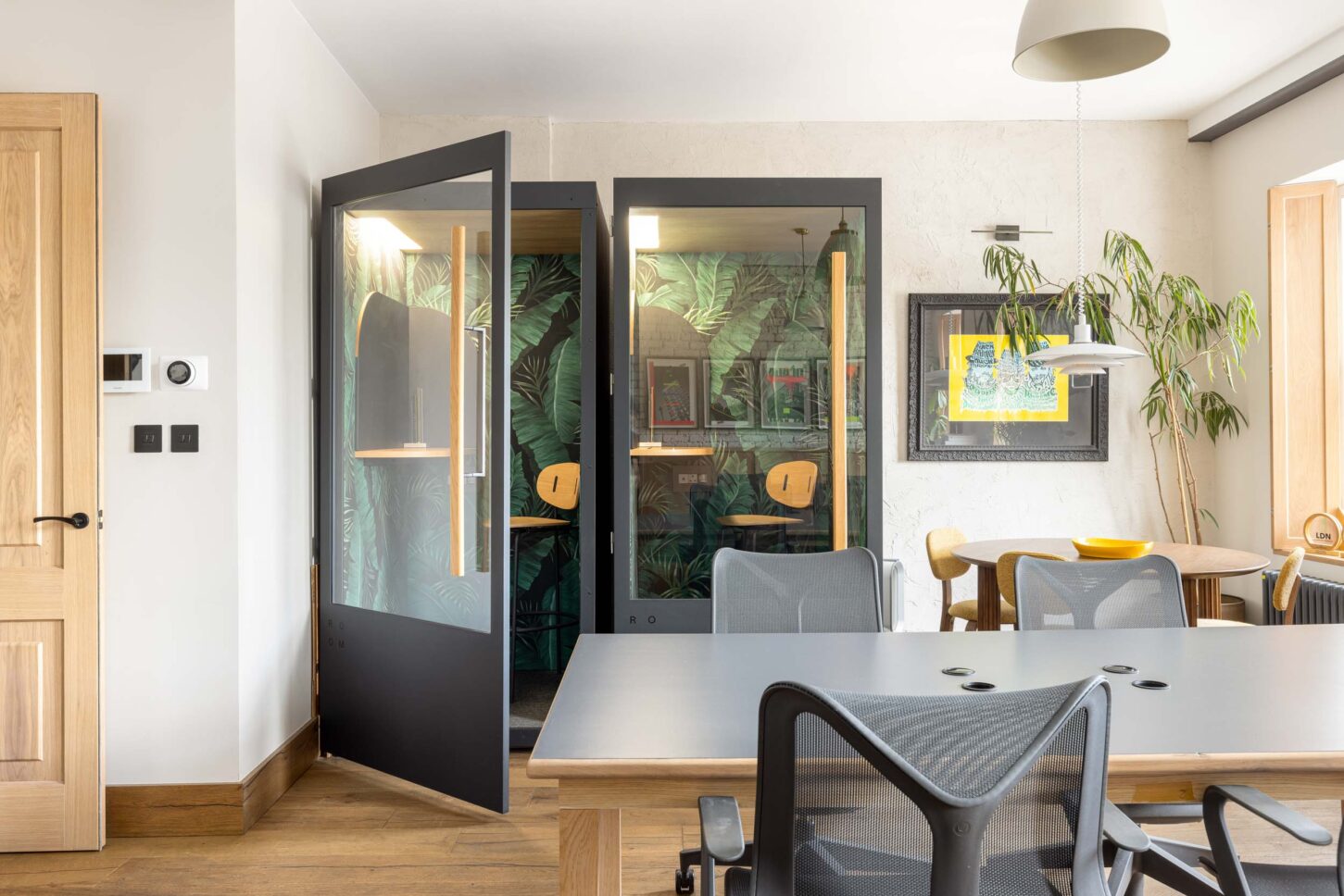Office phone booths with tropical wallpaper and glass doors, designed by Unknown Makers — Kingsland project, London