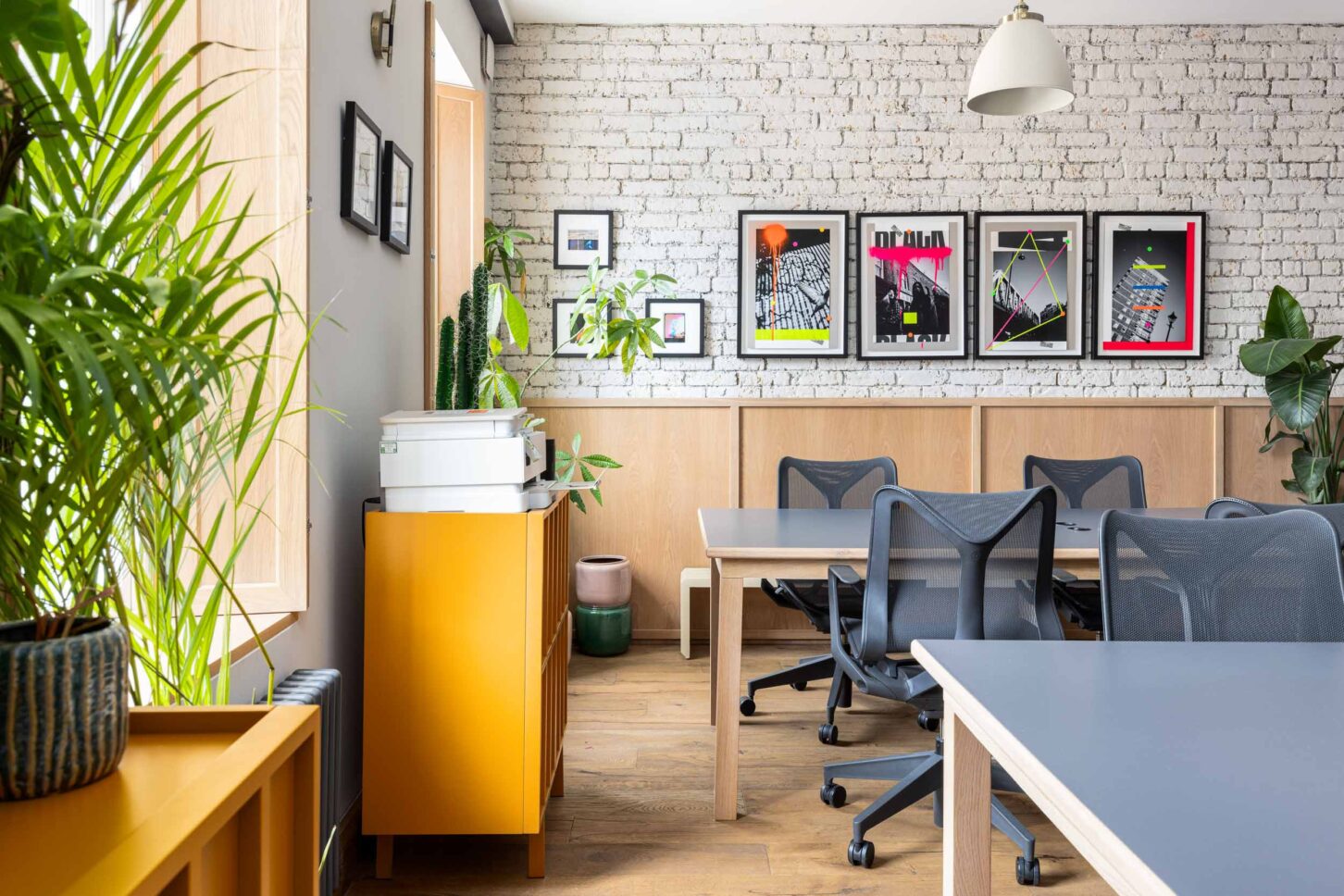 Office desks with brick wall gallery and framed art prints, designed by Unknown Makers — Kingsland project, London