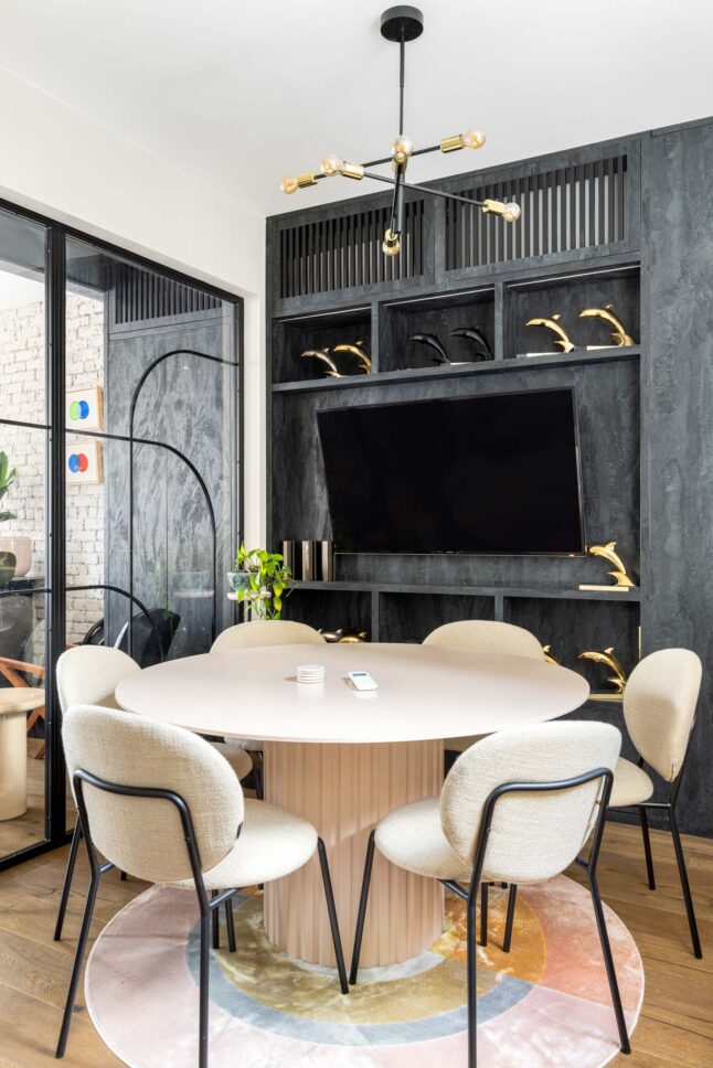 Office meeting room with round table and dark built-in cabinetry, designed by Unknown Makers — Kingsland project, London
