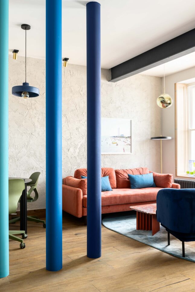 Office breakout lounge with painted columns and orange sofa, designed by Unknown Makers — Kingsland project, London