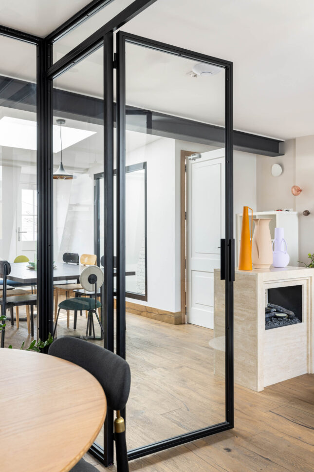 Office glass partition doors leading to dining area with fireplace, designed by Unknown Makers — Kingsland project, London
