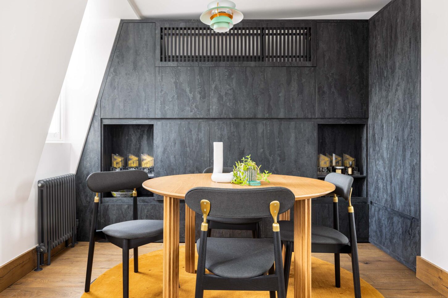 Office meeting nook with dark stone cladding and round table, designed by Unknown Makers — Kingsland project, London