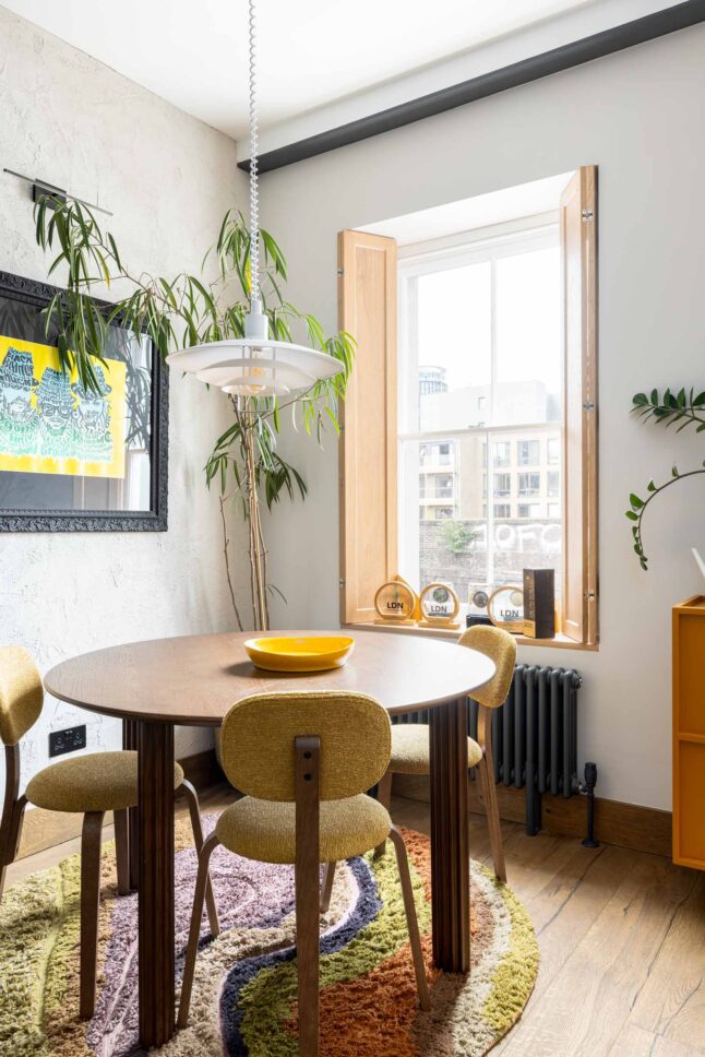 Office breakfast nook with round table and colourful rug, designed by Unknown Makers — Kingsland project, London